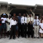 Terremoto en Haiti. Familia rezando delante de su casa destruida